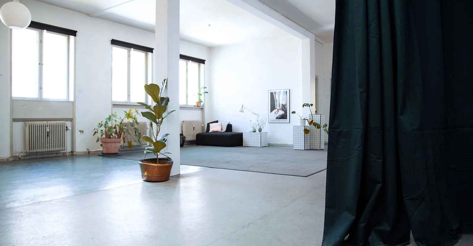 The large, bright hall with a pillar, plants and a dark curtain that can be drawn.